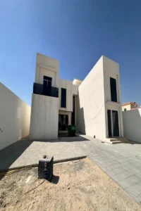 مدخل غائر لفيلا معاصرة في أبوظبي مع فتحات زجاجية مدروسة وإضاءة طبيعية