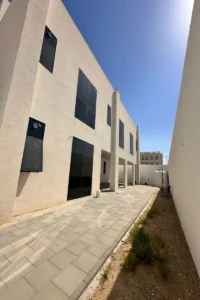 واجهة جانبية لفيلا سكنية في أبوظبي بفتحات زجاجية كبيرة وإطارات سوداء